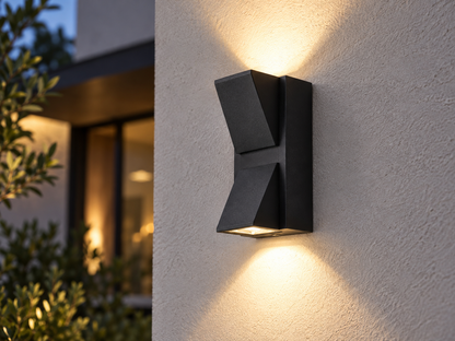 Faceted Tall black outdoor wall light throwing warm light both up and down the wall
