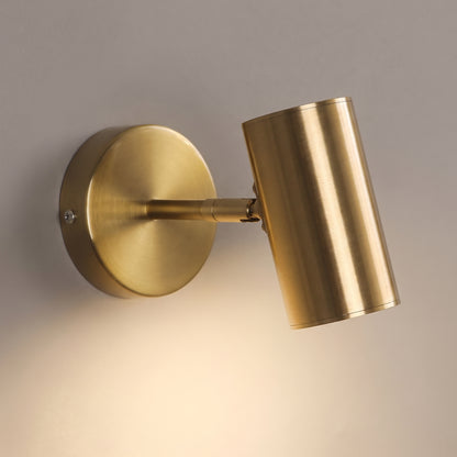 Close-up of the brushed gold wall spot light showing the machined swivel joint, round wall plate and recessed diffuser