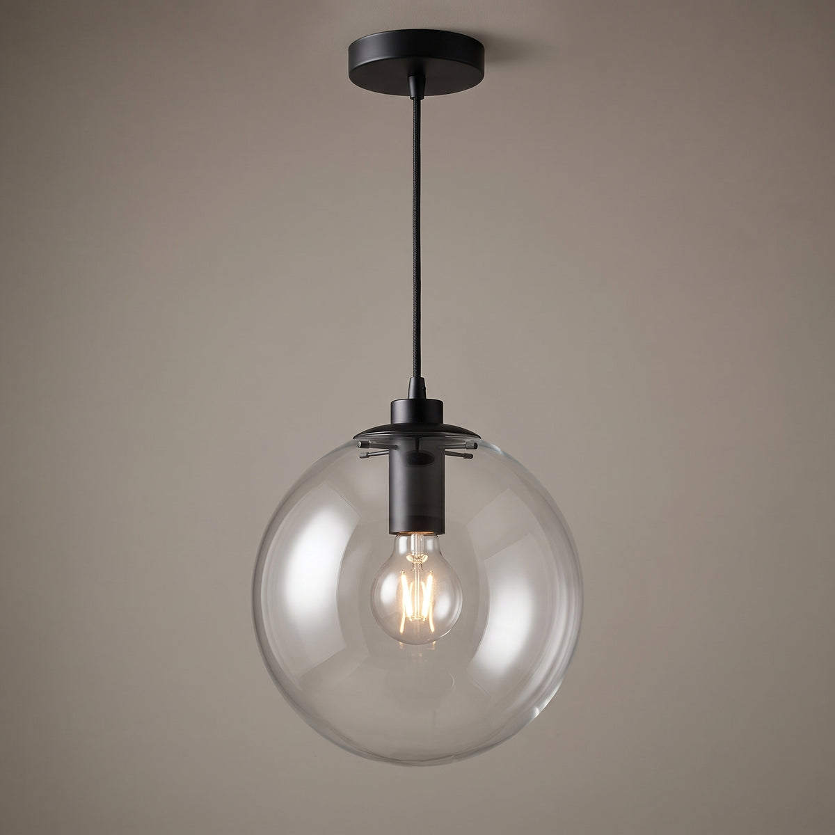 Black finish option: clear glass globe pendant light with a matt black collar, cord and ceiling canopy