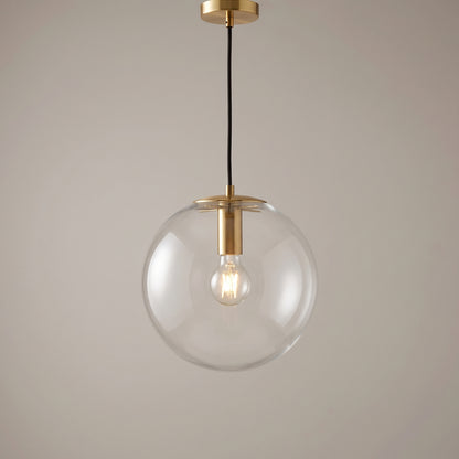 Gold finish option: clear glass globe pendant light with a polished brass collar and ceiling canopy