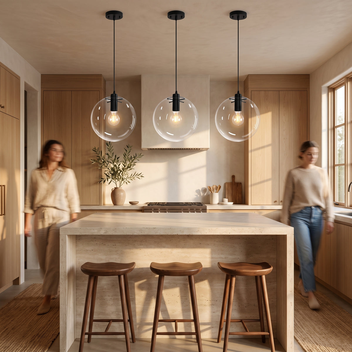 Three clear glass globe pendant lights hung in a row above a travertine kitchen island with walnut bar stools