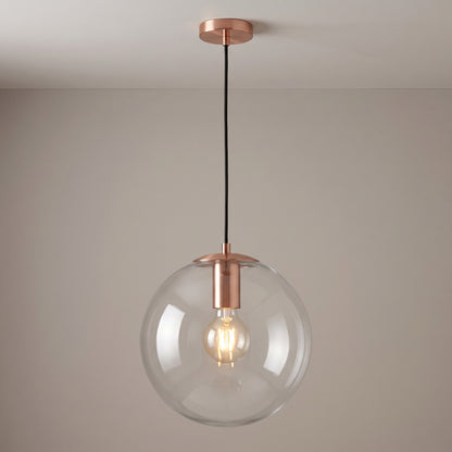 Rose gold finish option: clear glass globe pendant light with a brushed copper collar and ceiling canopy