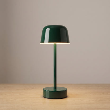 Dark green colour option: cordless mushroom table lamp in glossy forest green on a light oak surface