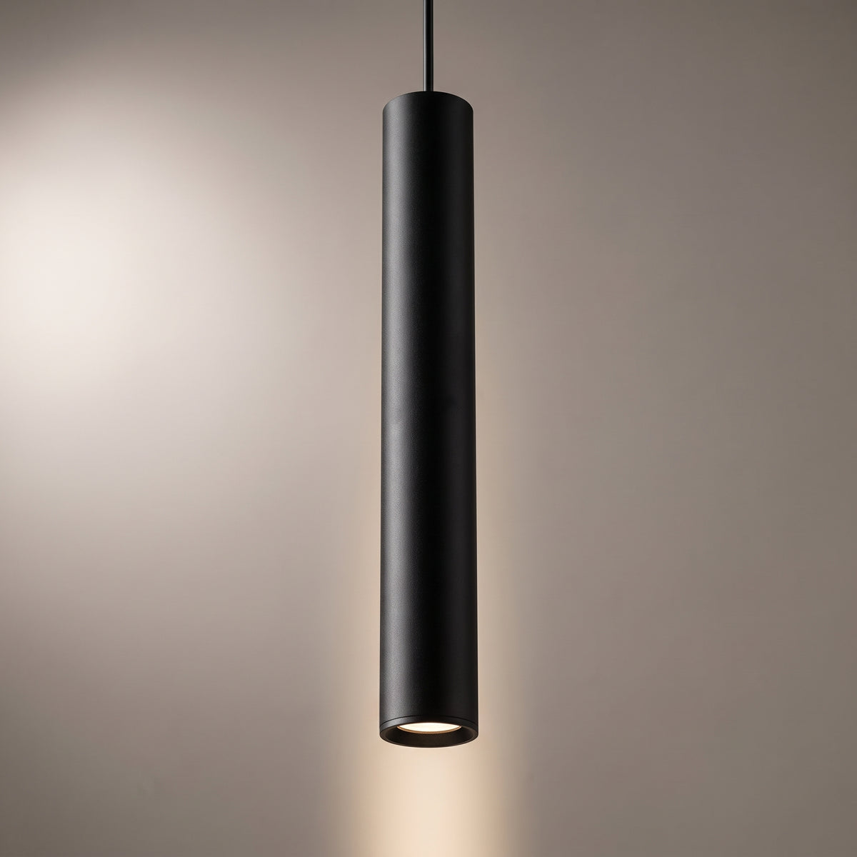 Close-up of the matt black aluminium tube pendant showing the machined open end and the recessed LED lens