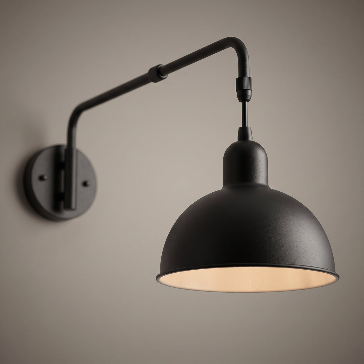 Close-up of the swing arm wall light showing the telescopic collar, the elbow joint and the warm painted inside of the dome shade