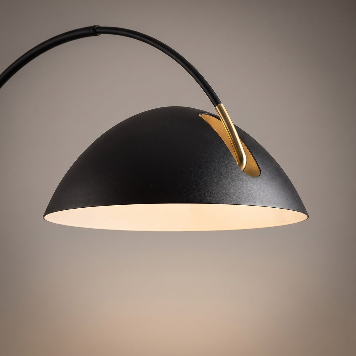 Close up of the matte black metal shade with white interior and brass joint detail