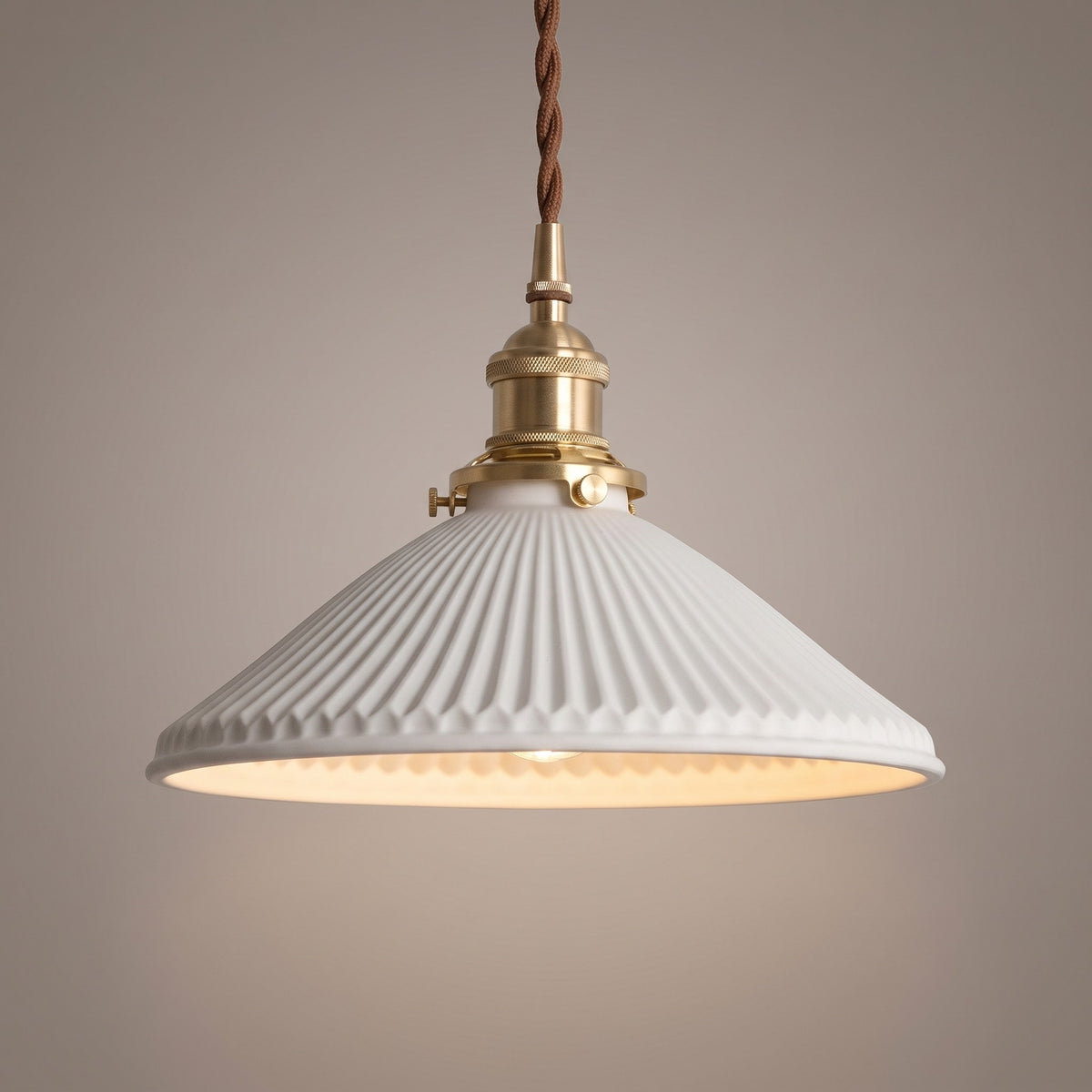 Close up of the fluted white ceramic shade, brass holder and twisted brown cord