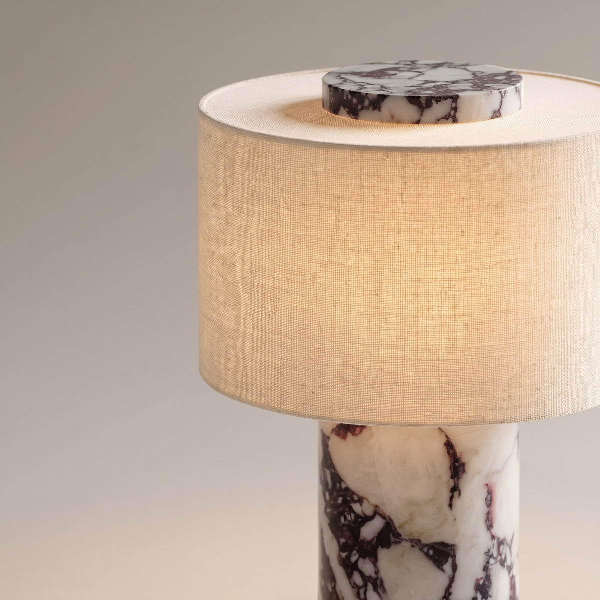 Close up of the viola marble base, linen shade and marble top disc of the table lamp