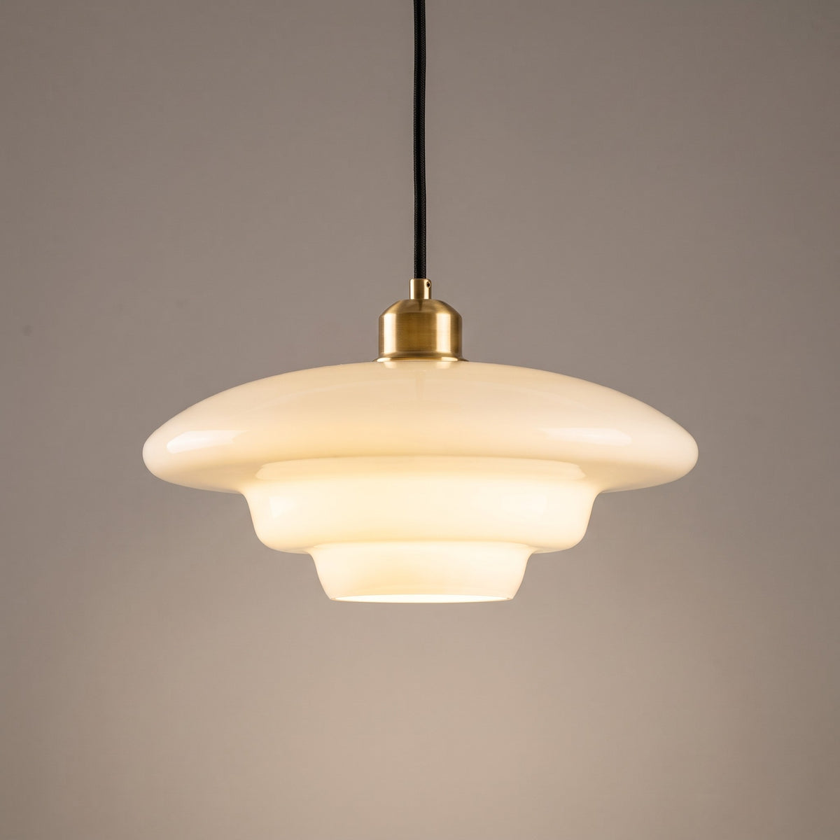 Close up of the opal glass shade, tiered step and polished brass cap