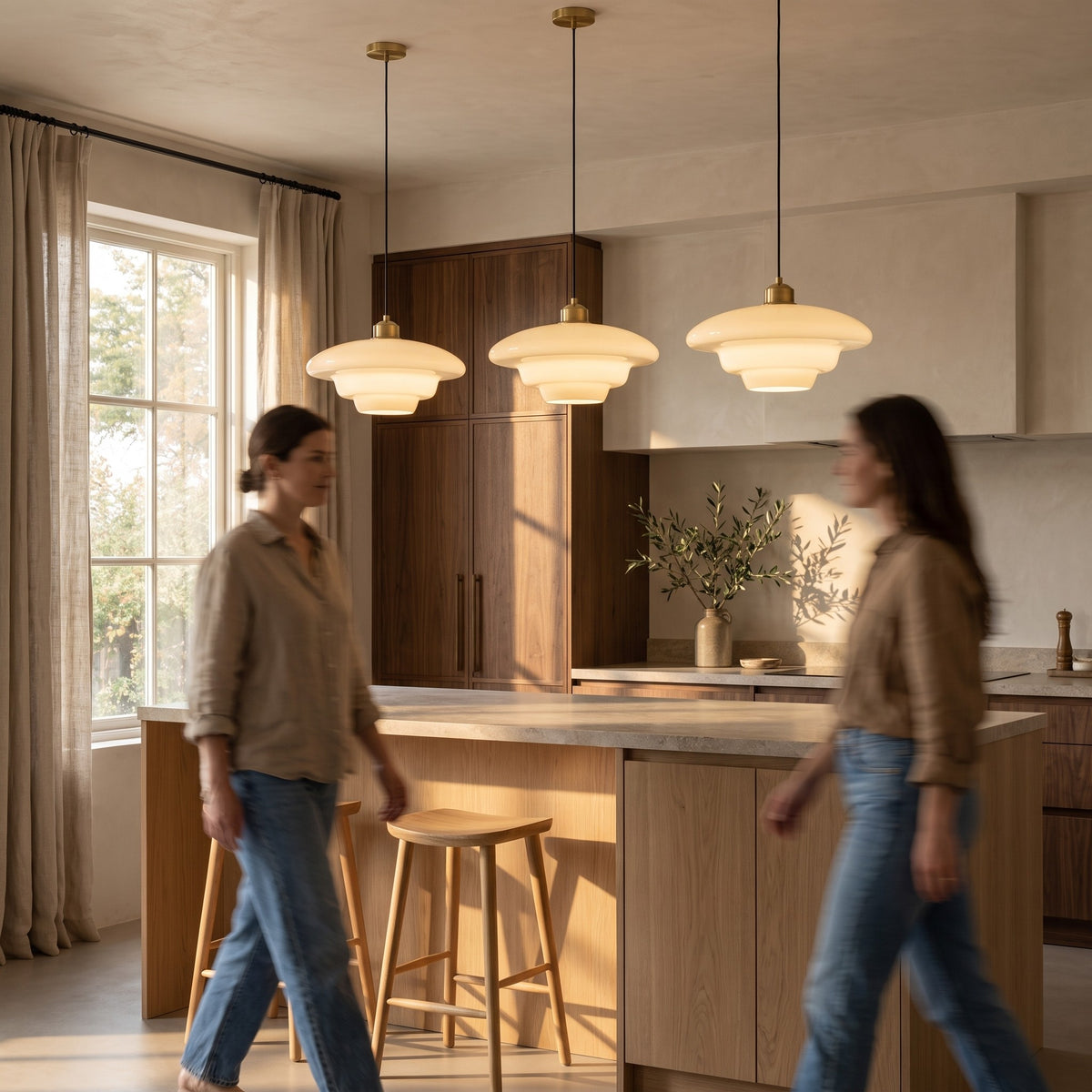 Three opal glass pendants in a row above a light oak kitchen island