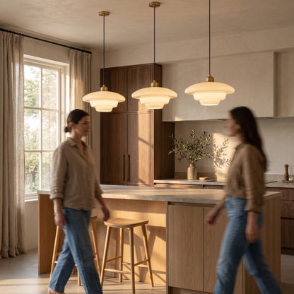 Three opal glass pendants in a row above a light oak kitchen island