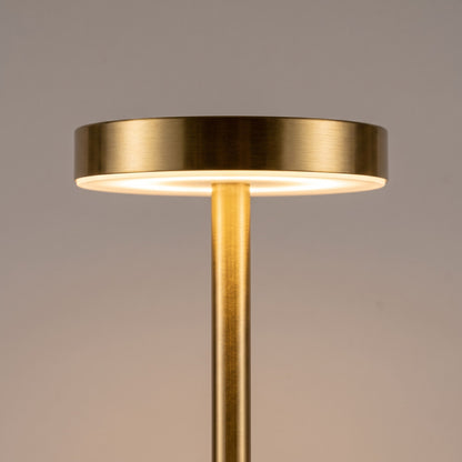 Close up of the brushed gold top disc and LED ring of the slim cordless lamp
